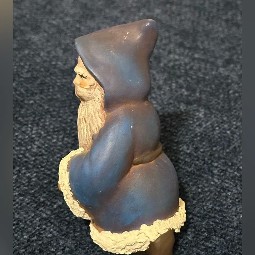 Cute blue robed kneeling Santa. He carries a basket of gifts.